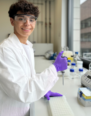 Marcos Nadales Neira steht mit einer Pipette in der Hand im Labor. Marcos Nadales Neira stands in the laboratory with a pipette in his hand.