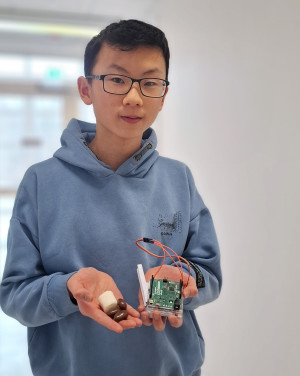 Leon hält Marshmallows, Schokolade und die Hardware für sein Projekt zur Bilderkennung.