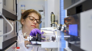 A female researcher uses the mass spectrometer.