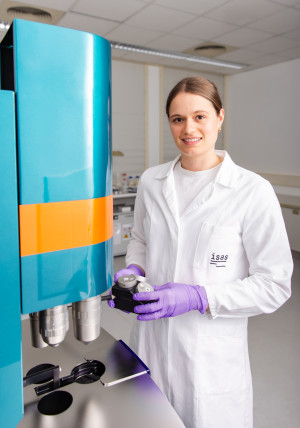 Leonie Menzel standing in front of the light sheet fluorescence microscope.