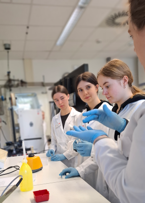 Luisa Speicher erklärt drei Mädchen den Vortexmischer.